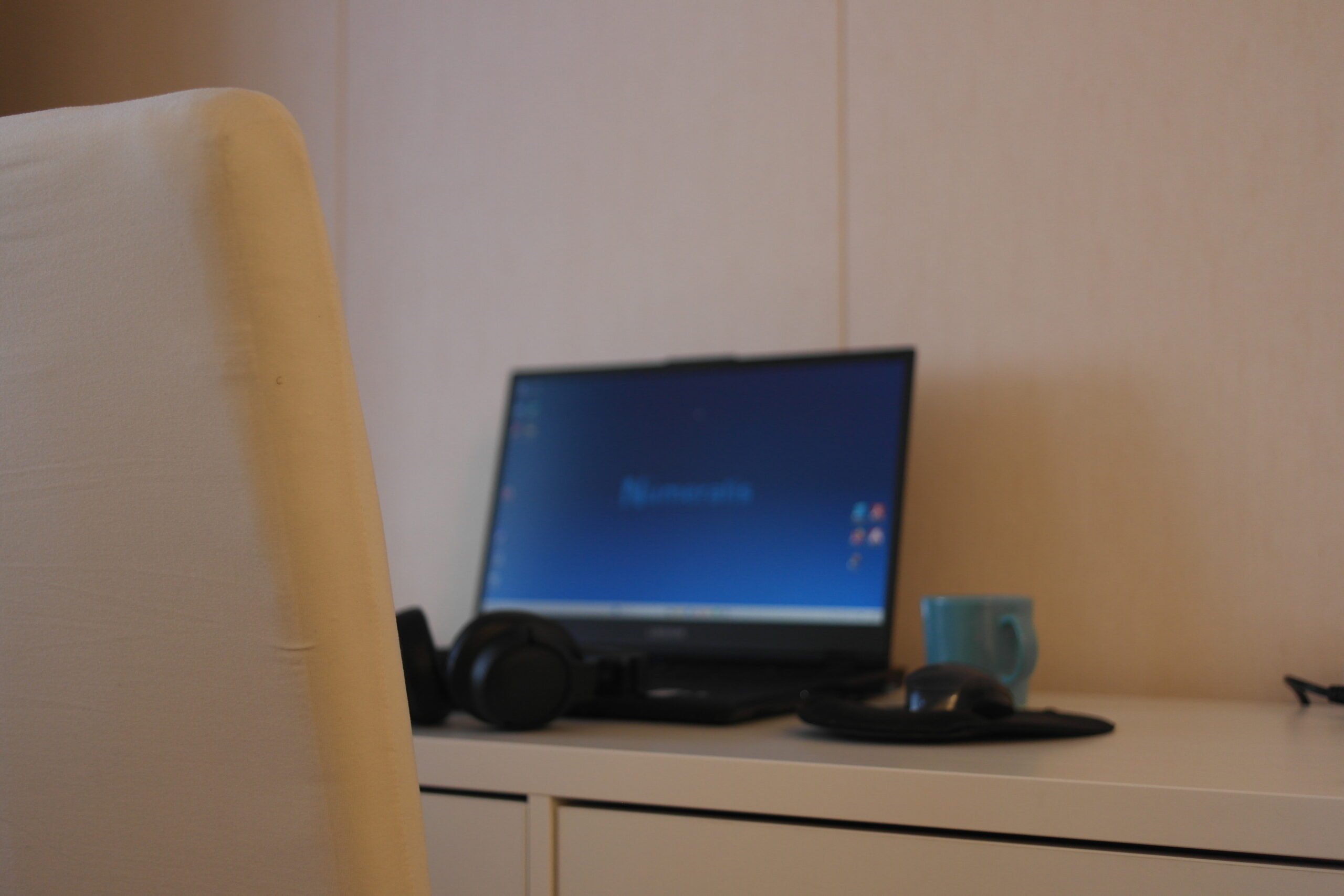 Kuvassa toimiston pöydällä tietokone ja kuppi kahvia